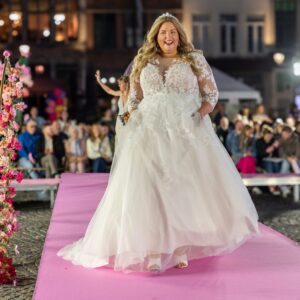 Romy dans la robe de mariée Mori de White One lors du défilé de mode sur la Grand-Place de Malines.