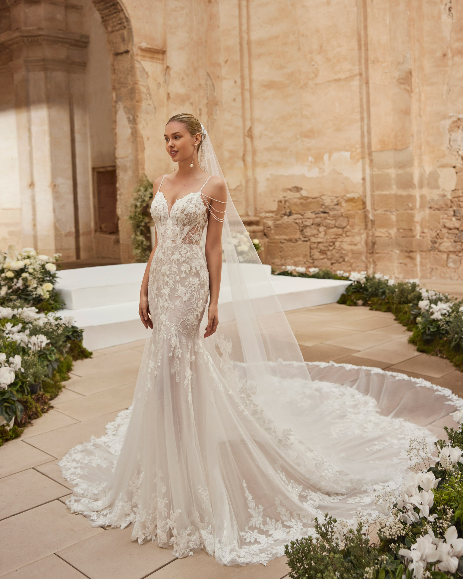 Marisela Aire Barcelona mermaid trouwjurk met indrukwekkende sleep, kant met pareltjes en prachtige afhangende parelbandjes. Tijdloos, klassevol én elegant