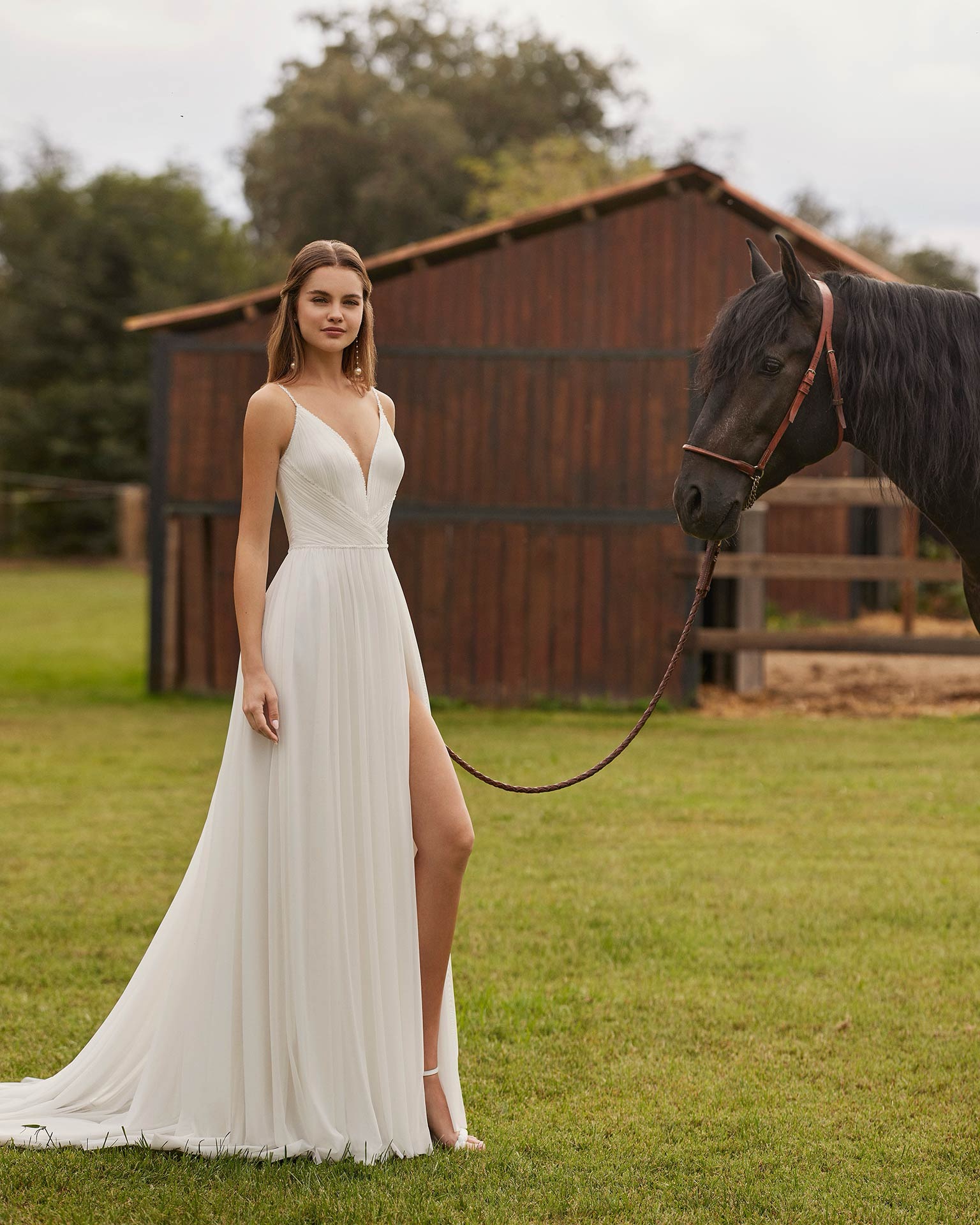 Niler Alma Novia by Rosa Clara. Zeer verfijnde A-lijn trouwjurk met plissé bovenstuk en split.