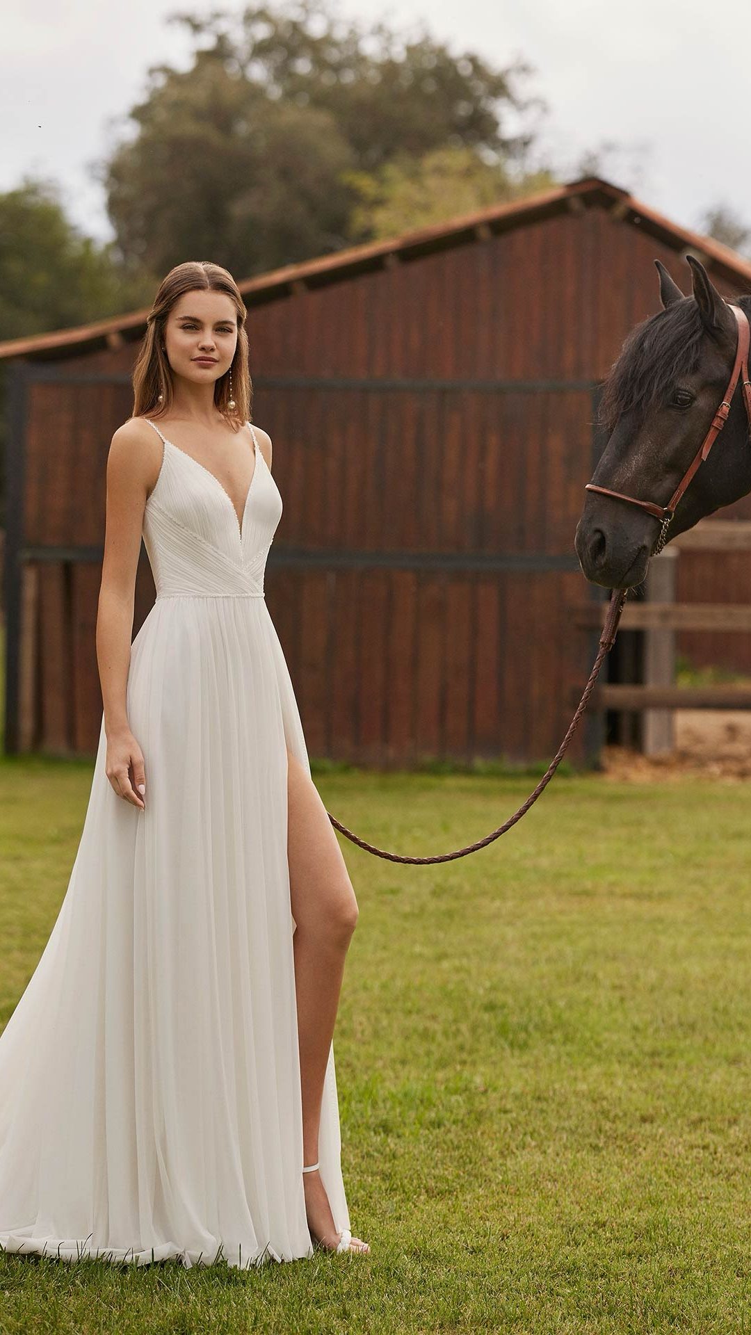 Niler Alma Novia by Rosa Clara. Zeer verfijnde A-lijn trouwjurk met plissé bovenstuk en split.